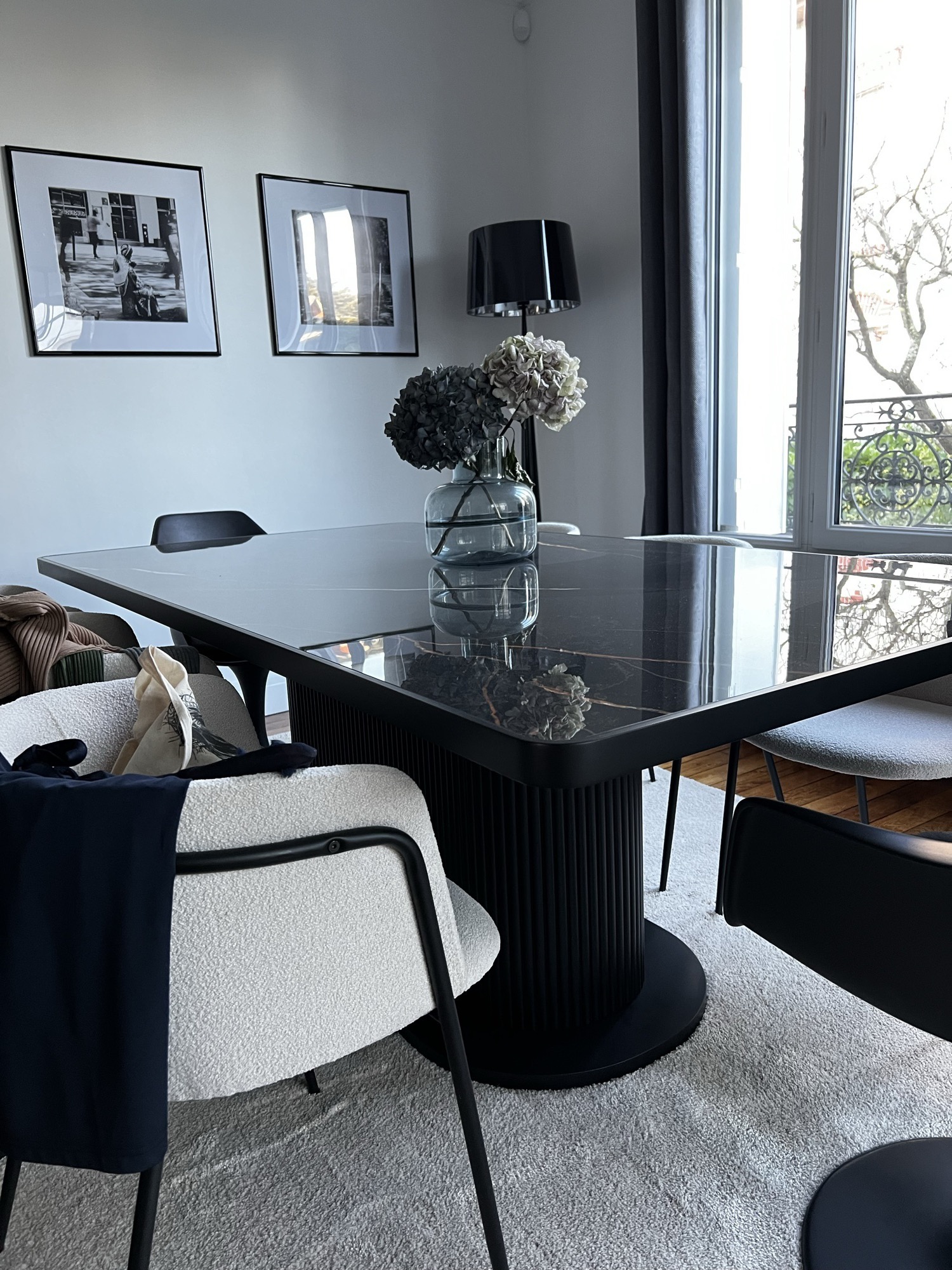 Mesa preta com vasos e cadeira boucle