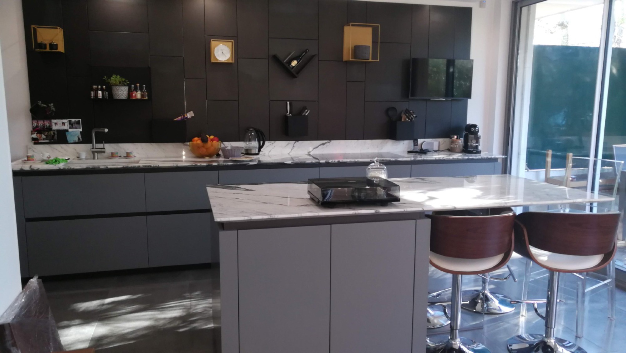 Cozinha cinza com ilha em mármore e bancos