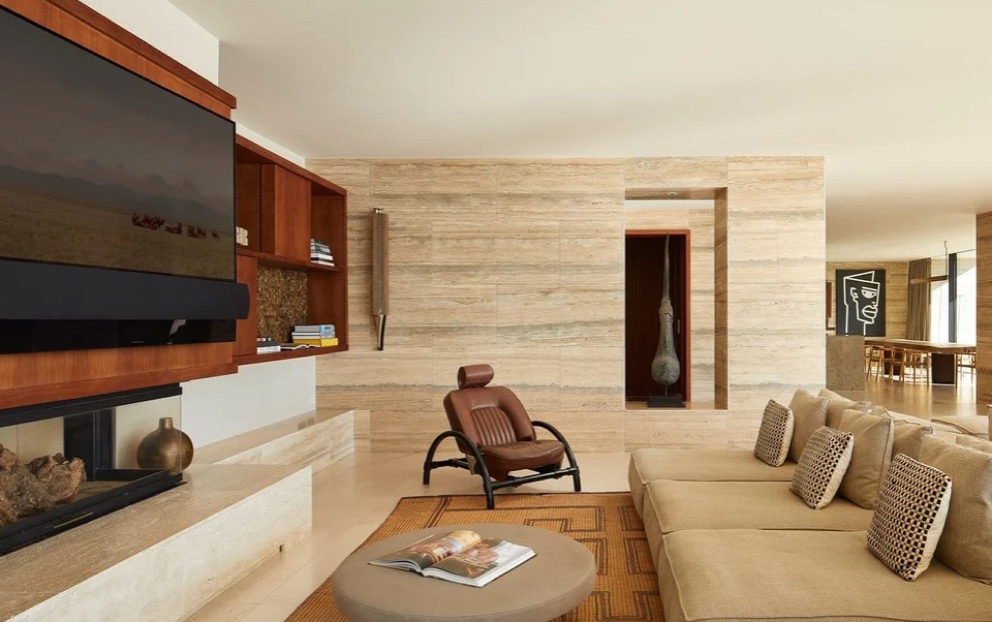 Sala de estar com painel de TV e sofá bege