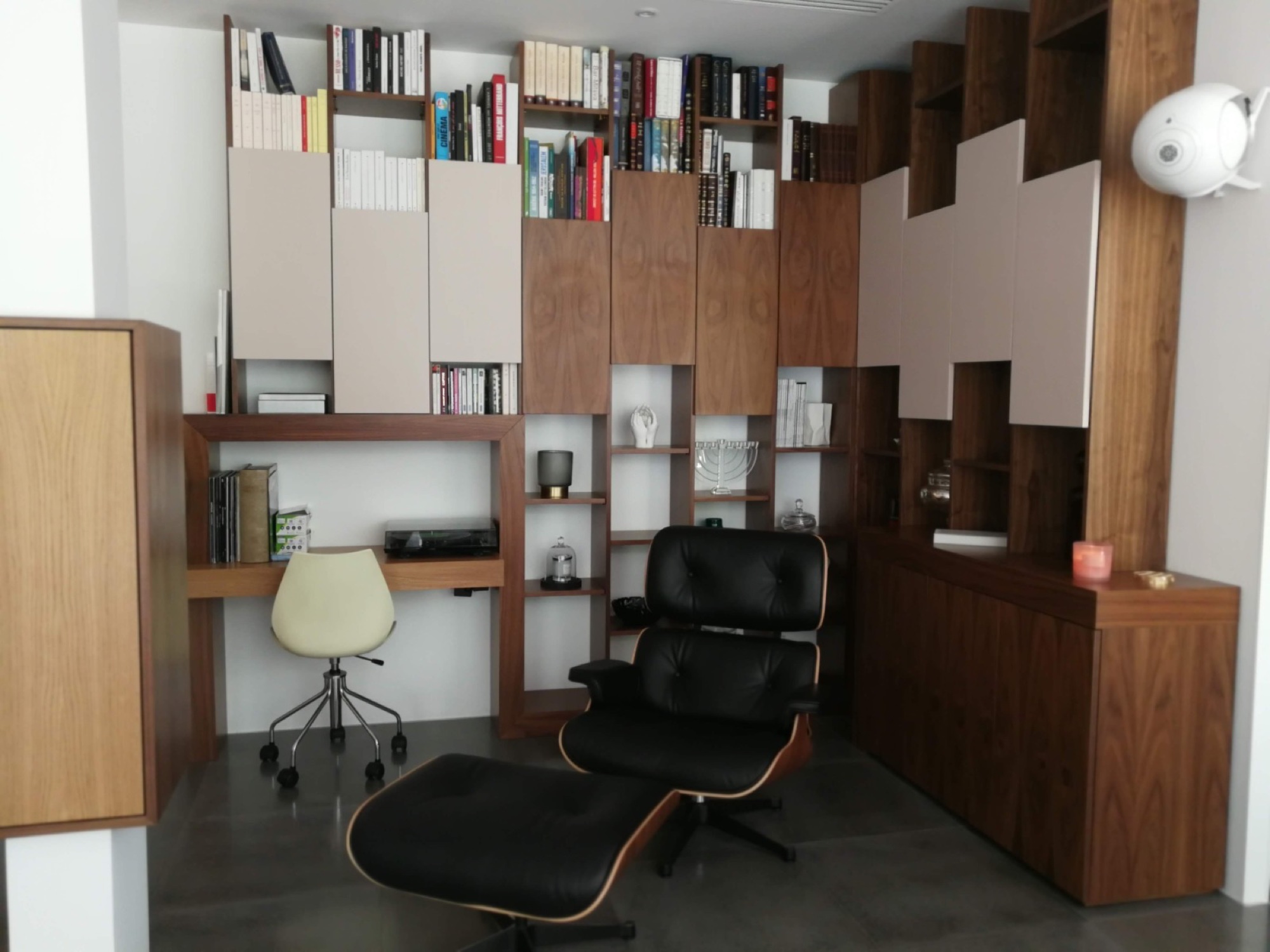 Sala de leitura com estante e poltrona