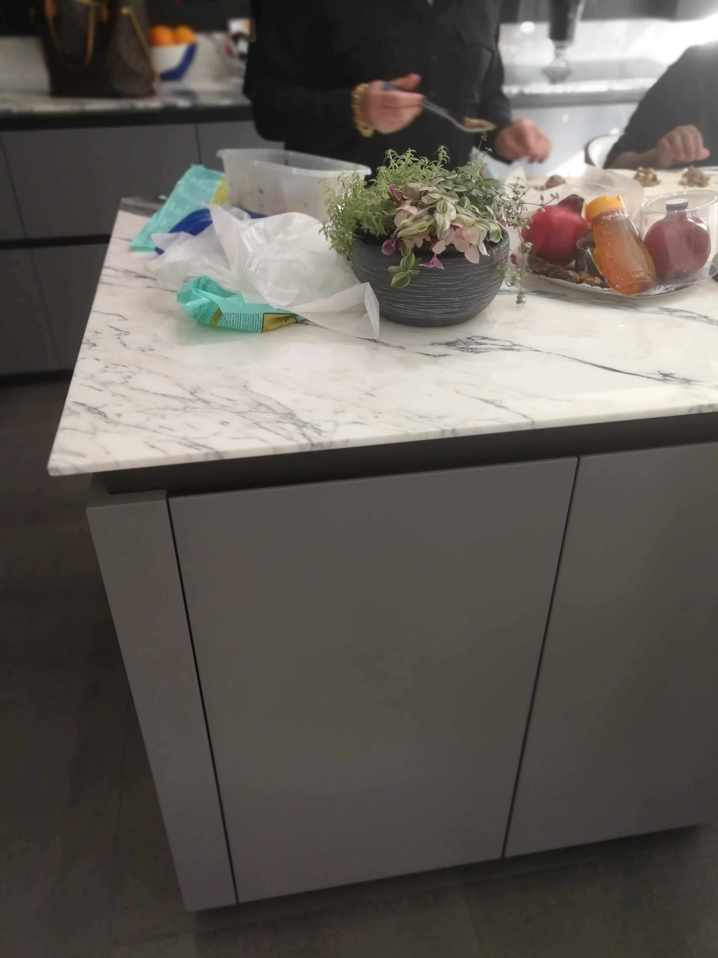 Ilha da cozinha com bancada em marmore branco veiado e armarios cinza mate