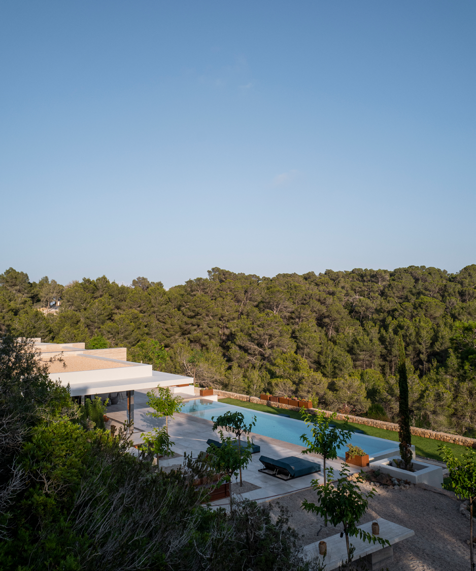 Vista aerea da villa Can Kef integrada na paisagem de pinheiros com piscina infinita e terracos