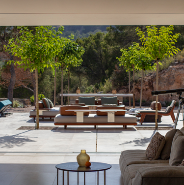 Vista do terraco com mobiliario lounge em madeira e tecido, mesa de apoio e piscina ao fundo